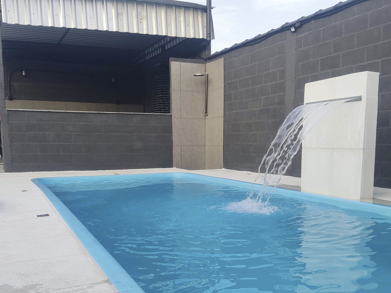 Piscina e chuveiro ao lado da churrasqueira no Festa em Blocos