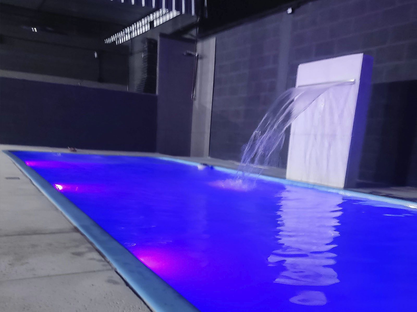 Piscina com iluminação colorida à noite