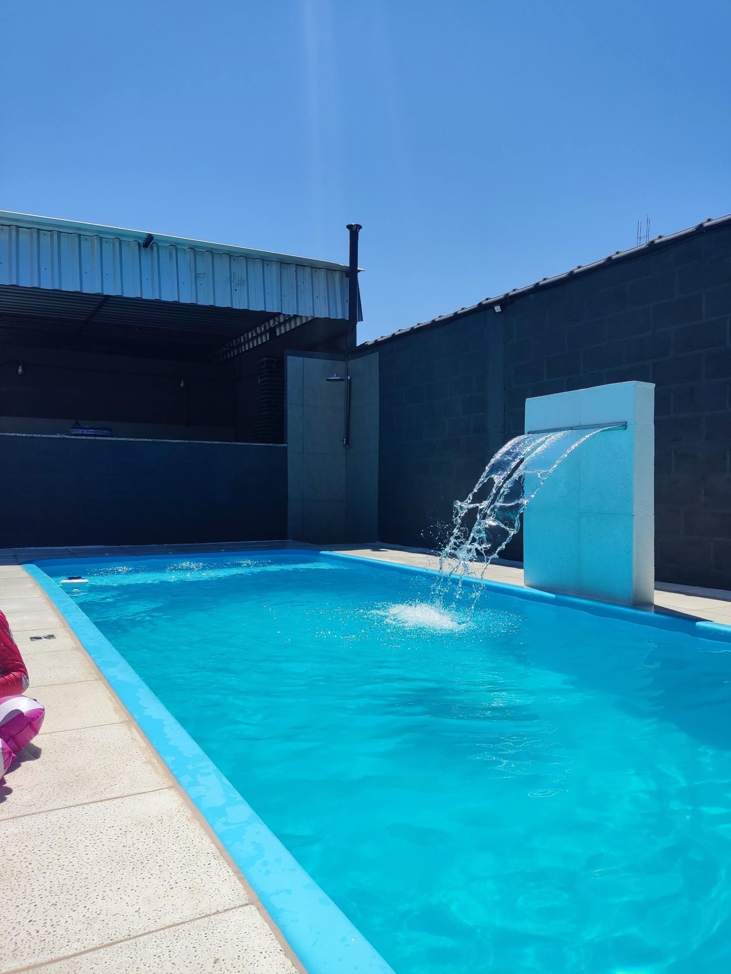 Piscina com cascata contra o céu azul no salão de festas Festa em Blocos, em Belford Roxo